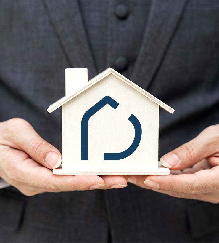 close up to a man holding a mock house with deyar logo on it