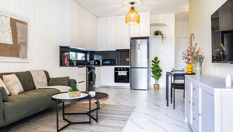 Abraj 101 apartment living room furniture couch and table and the kitchen cabinets, sink, stove, and refregirator.
