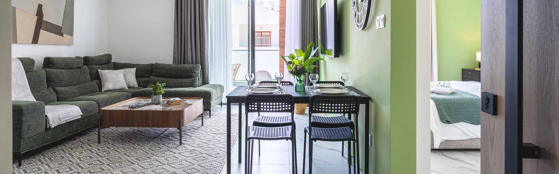 abraj 202 apartment's modern living room with furniture, table, tv, couches, balcony and bedroom.