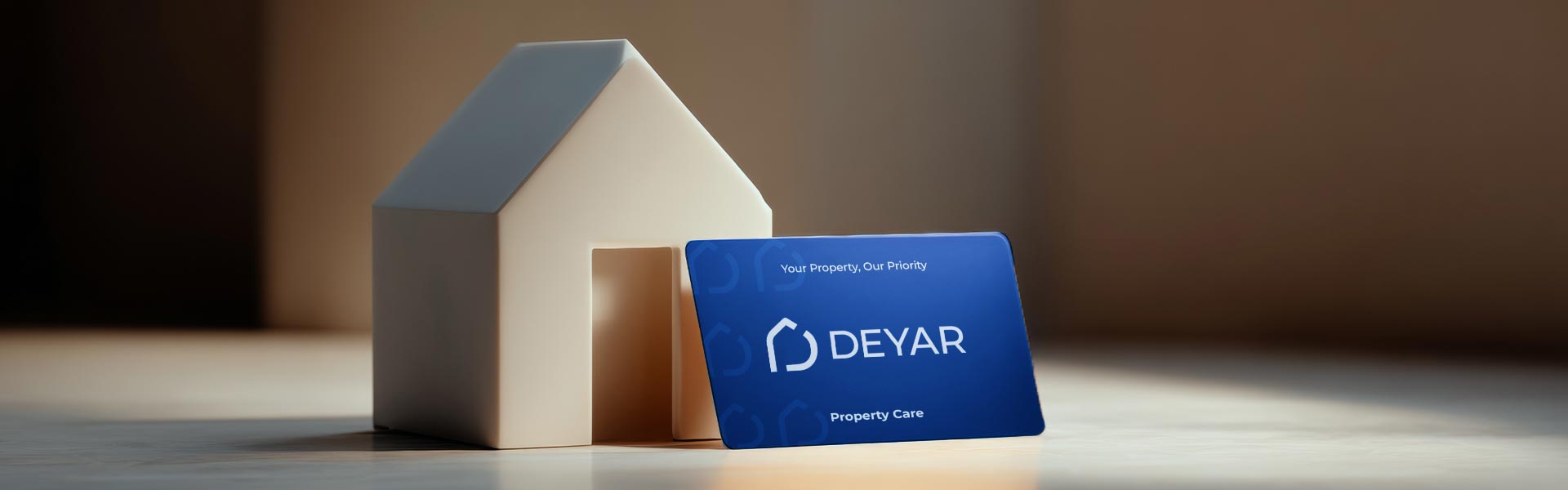a 3d house modal with deyar business card leaning on it with a blured background